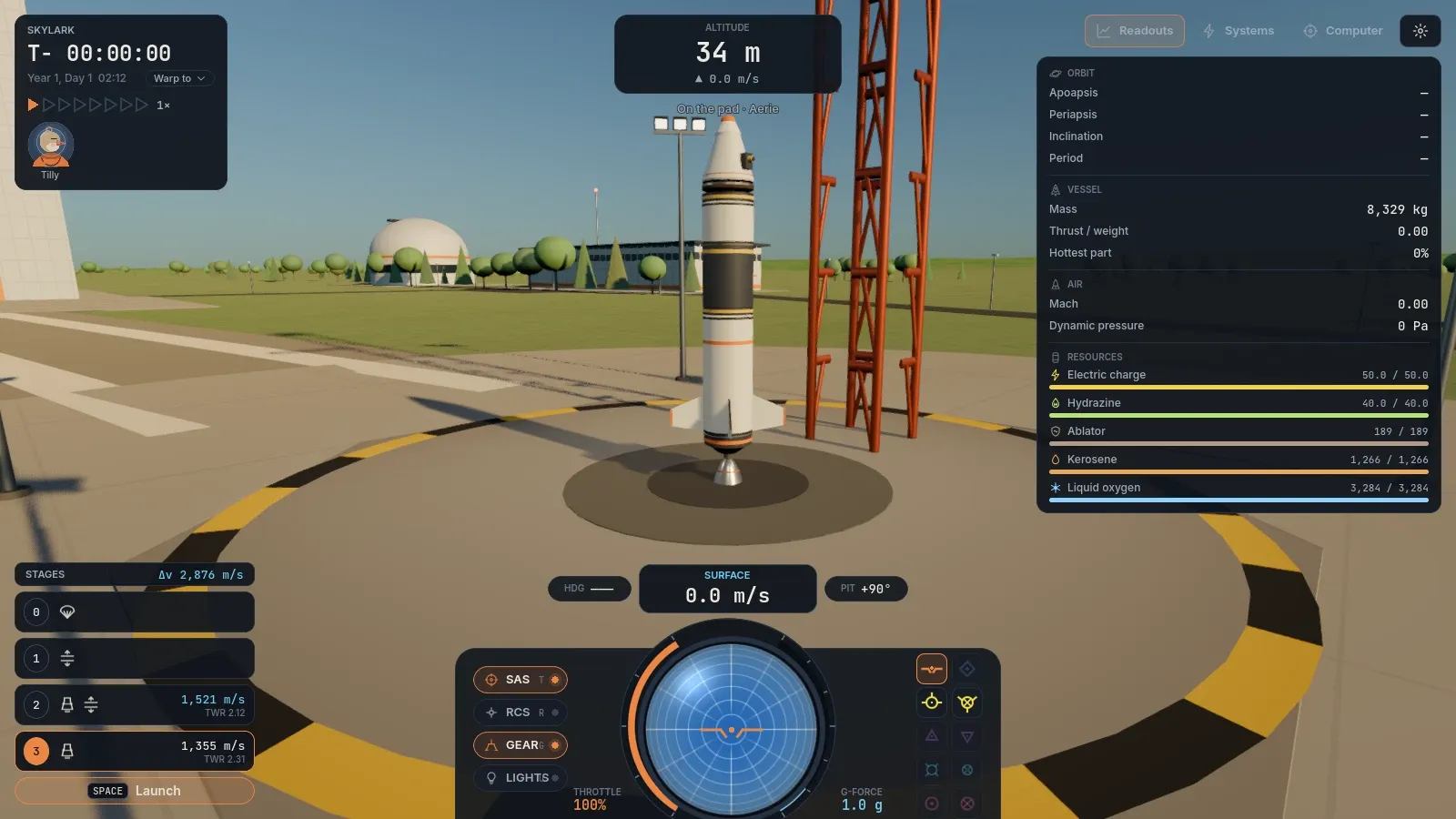A rocket on the launch pad beside its tower, with the space center's buildings behind it.